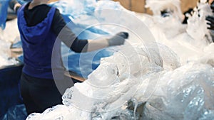 Workers select and sort garbage that travels on a conveyor belt in a waste recycling plant, sorting