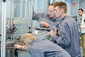 workers setting up factory production machinery