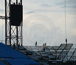 Workers setting up grandstand seating.