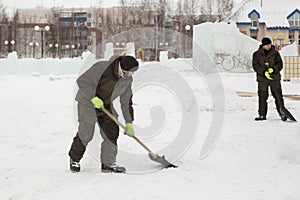 Workers shovels to remove the snow on the ice town