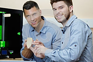 workers showing product created by 3d printer