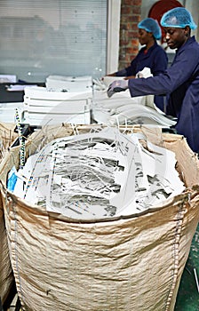 Workers, shredding and printing with paper, bag and documents for distribution, media and press. Employees, factory and