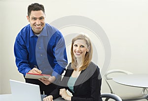 Workers smile near desk