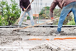 Lavoratori diffondersi calcestruzzo Attraverso piatto 