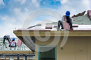 Workers are on steel frame for new roofing tiles.