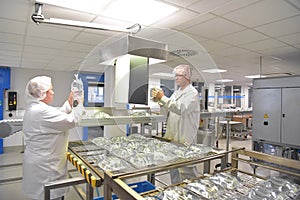 Workers in sterile protective clothing for quality control of in