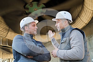 Workers stood underneath industrial turbine