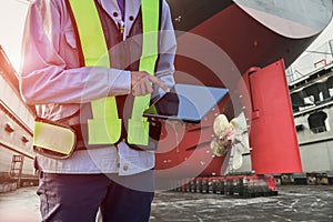 Workers with tablet in hand at floating dry dock in shipyard