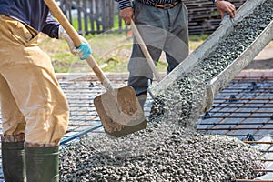 Workers take concrete from the tray to the slab