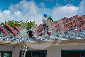 Workers are tiling new roof tiles.