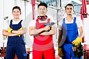 Workers with tools in Asian industrial factory