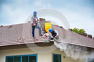 Workers are trimming roof tiles with electric saws.