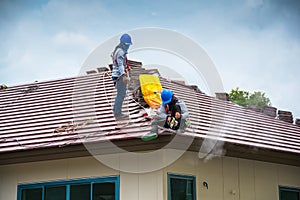 Workers are trimming roof tiles with electric saws.