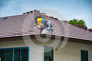 Workers are trimming roof tiles with electric saws.