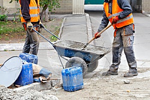Workers in a trolley prepare concrete for repairing road curbs