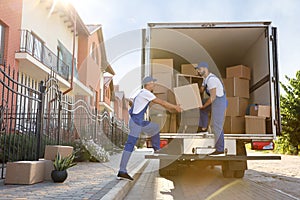 Workers unloading boxes from van. Moving service