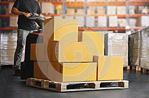 Workers Unloading Package Boxes on Pallets in Warehouse. Electric Forklift Pallet Jack Loader.