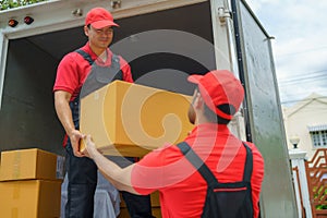 Workers are unloading stuff from a truck to move to a new house