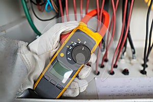 Workers use clamp meter to measure the current of electrical wires produced from solar energy for confirm to normal current