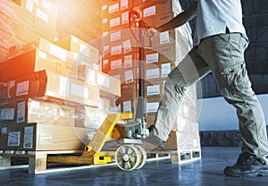Workers using Hand Pallet Jack Unloading Package Boxes. Commerce Supply Chain. Shipment Storage Warehouse Cargo Shipping Warehouse