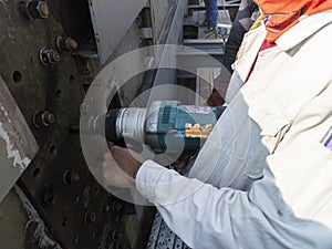 Workers are using a Impact Wrench to torque bolts to hold the splice plate with steel girder at splice joint of steel structure