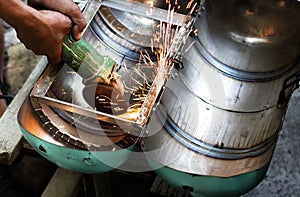 Workers using a metal grinding machines to cut workpieces made o