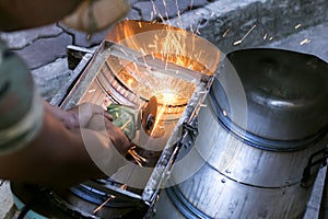 Workers using a metal grinding machines to cut workpieces made o