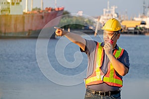 Workers are using radio communication and pointing forward at shipping port