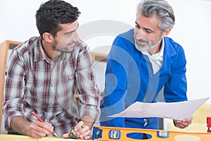 Workers using spirit level against workshop