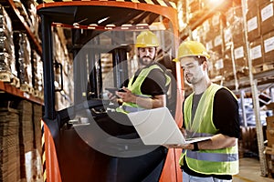 Workers using technology forklift in warehouse