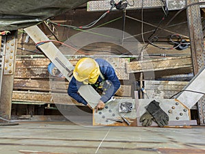 Workers are using a wrench to torque bolts to hold the splice plate to the steel beam of steel structure work