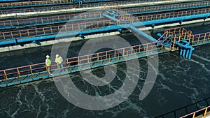 Workers walking along the pipes at a sewage treatment plant