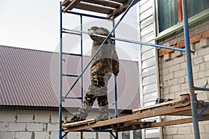 Workers walling the house with wall siding