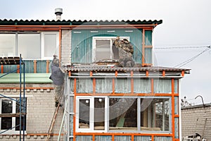 Workers walling the house with wall siding