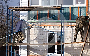 Workers walling the house with wall siding