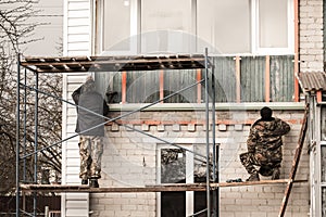 Workers walling the house with wall siding