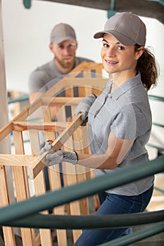 workers in warehouse carrying furniture