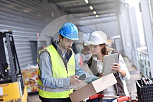 Workers in warehouse checking on recpetion of goods