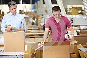 Workers In Warehouse Preparing Goods For Dispatch