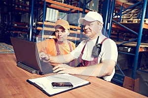 workers in warehouse with rack arrangement stillage on background