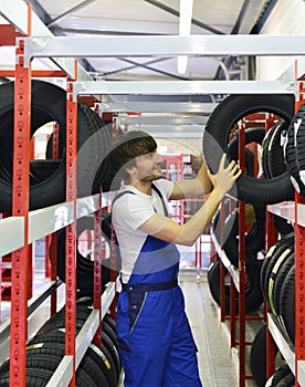 Workers in a warehouse with tyres for changing the car