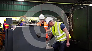 Workers wearing safety hat command computer to produce products by automate robot machines in factory workshop