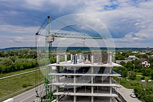 Workers work with crane and steel concrete reinforcement at large construction site of modern building. Modern monolithic