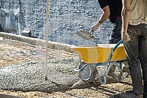 Workers loading concrete wheelbarrow photo