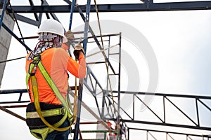 Workers are working on steel roof trusses with Fall arrestor device for worker with hooks for safety body harness on the