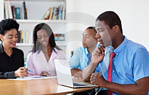 Working african american businessman with team and computer