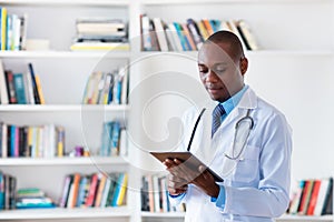 Working afro american male doctor with tablet computer and copy space