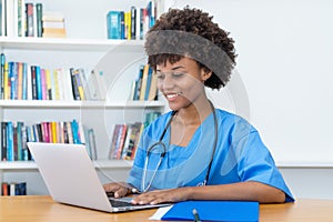 Working afro american nurse or medical student at computer