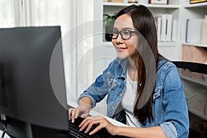 Working asian manager with glasses typing to search on pc. Stratagem.