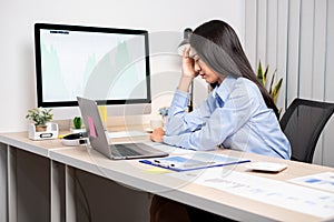 Working Asian women feel stressed, tired from work, migraine headaches from hard work while working at the office